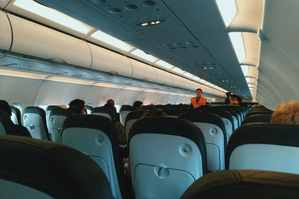Cabine d'avion avec les passagers assis, l'immobilité prolongée des longs trajets qui augmente le risque de thrombose veineuse dans les jambes