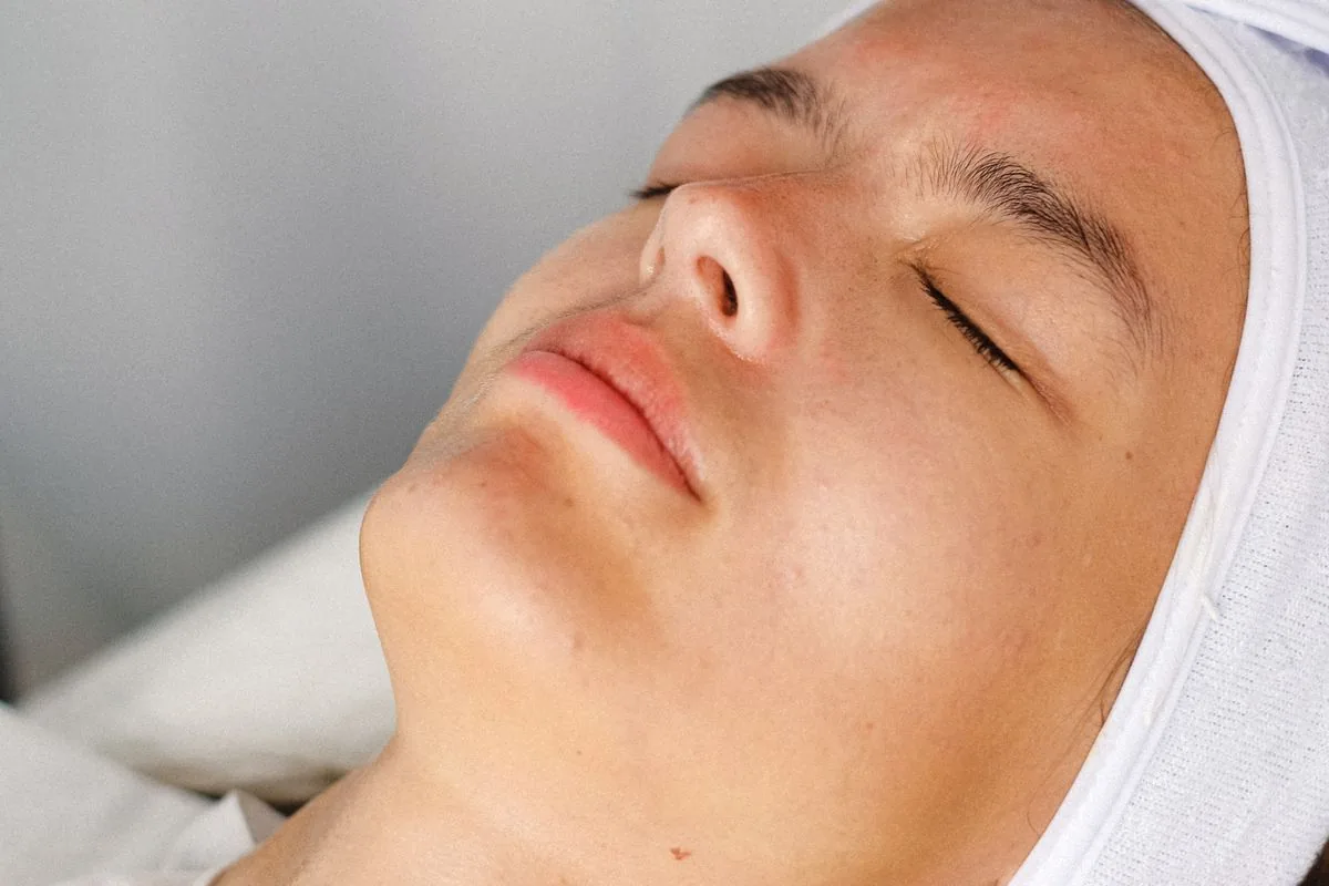 Visage détendu d'une patiente allongée sur la table de soins avec un bandeau, prête pour un soin HIFU 7D du visage